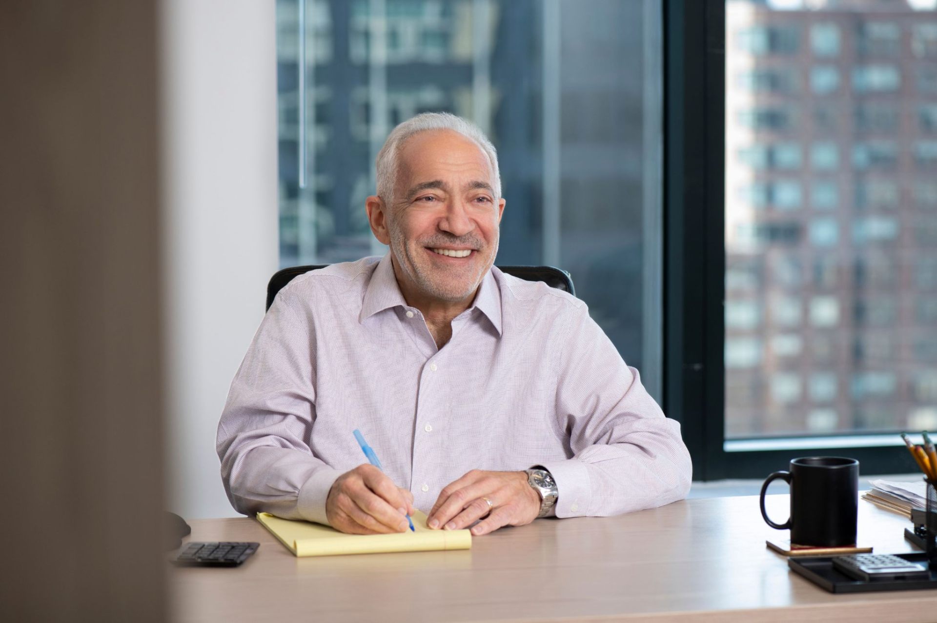 Larry Hirschfield, NYC Real Estate Developer and Founder of ELH Mgmt, seated at a desk